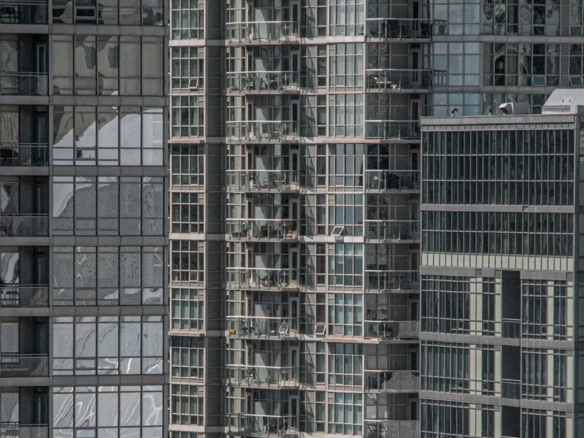 An image comparing liberty village vs fashion district condos with the Rogers Centre in the reflection of the glass.