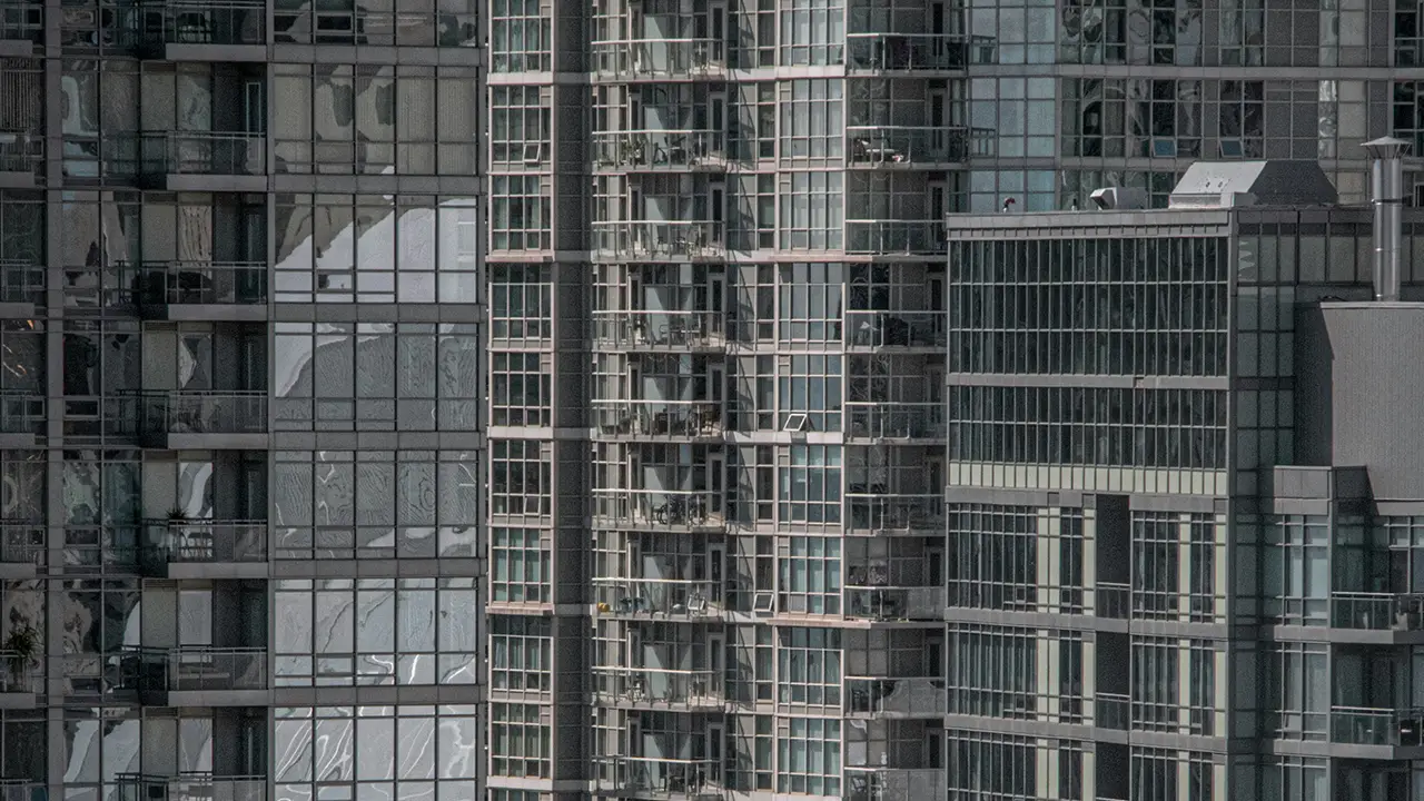 An image comparing liberty village vs fashion district condos with the Rogers Centre in the reflection of the glass.